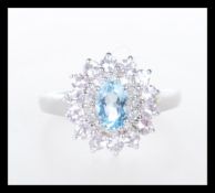 A hallmarked 9ct white gold ladies dress ring set with a central oval cut blue stone with two rows