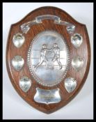A early 20th Century armorial oak shield back boxing trophy, having large silver plate relief