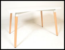 A contemporary white laminated and ash dining table. The table comprising of a laminated wooden