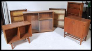 A pair of mid century retro oak sliding glass door bookcases together with a walnut glass bookcase