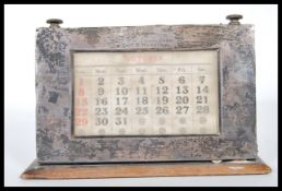 An early 20th Century Edwardian silver fronted  desk calendar, on plinth base, having rotating