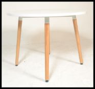 A contemporary white laminated and ash circular dining table. The table comprising of a laminated