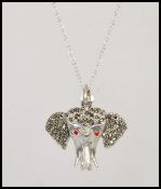 A stamped 925 silver pendant necklace having a pendant in the form of a elephant set with ruby