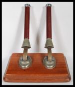 A vintage brewania pub double beer pump mounted on a wooden panel having turned wooden handles