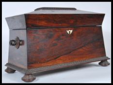 A 19th Century rosewood tea caddy of sarcophagus form having mother of pearl inlay to the lid,