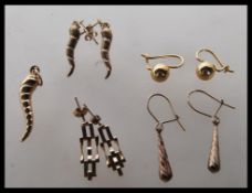 A selection of 9ct gold earrings of differing styles to include a pair of twist design earrings with