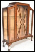A 1930's mahogany Queen Anne china display cabinet with central glass door having shelves to the