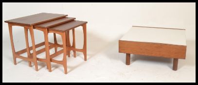 A 20th century teak wood nest of tables together with a teak wood and white melamine topped coffee