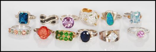 A collection of twelve stamped 925 silver dress rings to include a wild cat ring set with white