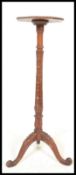A 20th Century oak Torchere plant stand, raised on floral carve tripod supports, having foliate
