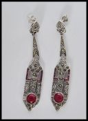 A pair of silver Art Deco style drop earrings of lozenge shape form, set with ruby stones and