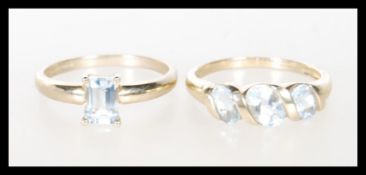 Two hallmarked 9ct gold dress rings to include a ring set with three oval cut blue stones in a