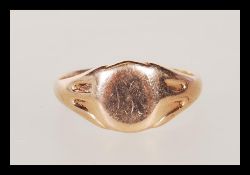 A hallmarked 9ct gold signet ring having a round cartouche to the head faintly engraved with the
