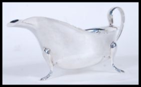 A silver hallmarked saucer boat being raised on three pad feet with shaped rims. Hallmarked