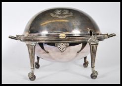 A silver plate muffin warmer raised on four legs with claw and ball feet, with gadrooned