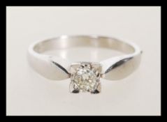 A hallmarked 9ct white gold solitaire ring illusion set with a brilliant cut diamond. Hallmarked