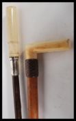 Two Victorian 19th Century walking stick cane tops. Both having ivory handles, one with leather band