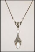 A silver and marcasite necklace pendant having two central opal panels on a silver chain. Stamped