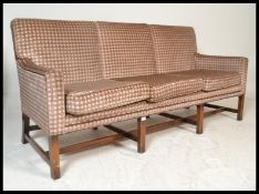 A 20th century Georgian revival mahogany frame high back sofa settee being upholstered in a velour