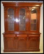 An impressive large Victorian style mahogany triple library bookcase cabinet. Raised on a plinth