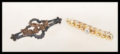 A 9ct gold bar brooch having rope twist design and ball decoration having a white stone to centre to