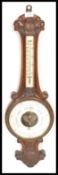 An early to mid 20th Century oak cased banjo aneroid barometer, white enamel dial below thermometer.