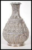 A 20th Century Persian Islamic silver vase of waisted form having repousse floral Middle Eastern