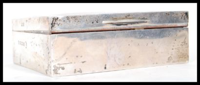 A silver hallmarked cigarette box having engine turned decoration to the lid with a panel to the top