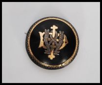 A 19th Century Victorian jet mourning brooch of round form having gilt borders and the initial ' W '