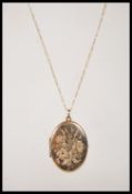 A stamped 375 9 ct gold necklace having a fine Figaro chain (stamped 375) with a locket pendant