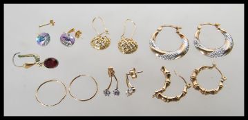 A selection of 9ct gold earrings to include a pair of two tone hooped earrings, a pair of pierced