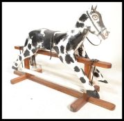 A large vintage early 20th Century rocking horse raised on wooden rocker base with painted mane