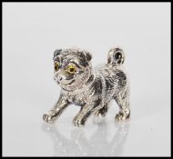 A sterling silver figure of a dog have coloured eyes. Stamped sterling 925 to base. Weighs 13.9g.