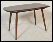 A mid 20th Century Ercol  beech and elm coffee table raised on tapering supports united with slatted