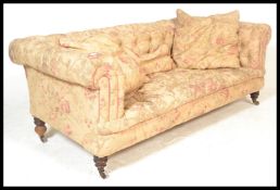 A late Victorian deep-buttoned back Chesterfield sofa with floral upholstery, feather filled