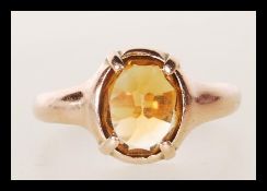 An 20th Century hallmarked 9ct gold ring set with a faceted orange stone. Hallmarked Chester 1912.