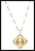 A hallmarked 9ct gold oval link necklace chain with a stamped 750 18ct gold pendant engraved with
