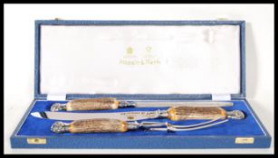 A Mappin and Webb cased three piece horn / antler handled carving set, consisting of a carving