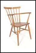 An early 20th century beech and elm wood Goldsmiths Windsor chair. Raised on turned legs united by