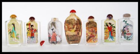 A group of seven 20th Century Chinese glass snuff bottles having reverse decorated scenes to the