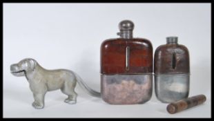 Two vintage 20th Century whisky flasks being leather bound with white metal cups having glass