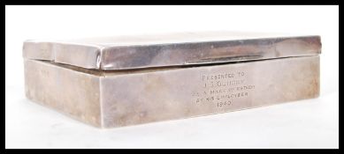 A silver hallmarked cigarette box having engine turned decoration to the lid and engraved initials