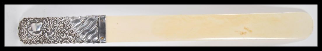 A 19th Century ivory and silver page turner having a silver handle with embossed scrolled