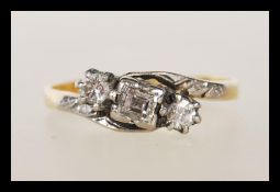 A mid 20th Century stamped 18ct gold and platinum ring set with a central square cut diamond flanked