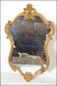 A 20th Century Rococo gilt framed wall mirror,  of cartouche form in the Rococo style.Measures 100cm