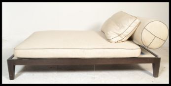 A contemporary Manhattan chaise longue / daybed by Oka, the frame raise on a ebonised base supported