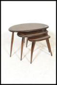 A vintage / retro set of Ercol beech and elm retro pebble nest of tables, shape 354. Each raised