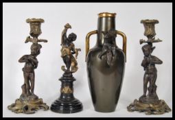 A 20th Century garniture of mantelpiece ornaments to include a pair of cast metal figural