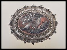 A pretty Victorian hallmarked silver sweetheart brooch, chase engraved to the front with a