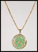 A gold on silver stamped 925 Chinese Jade pendant of circular form, having Dragon and Phoenix